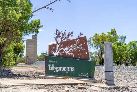 Tallygaroopna town entry sign, railway line and silos.